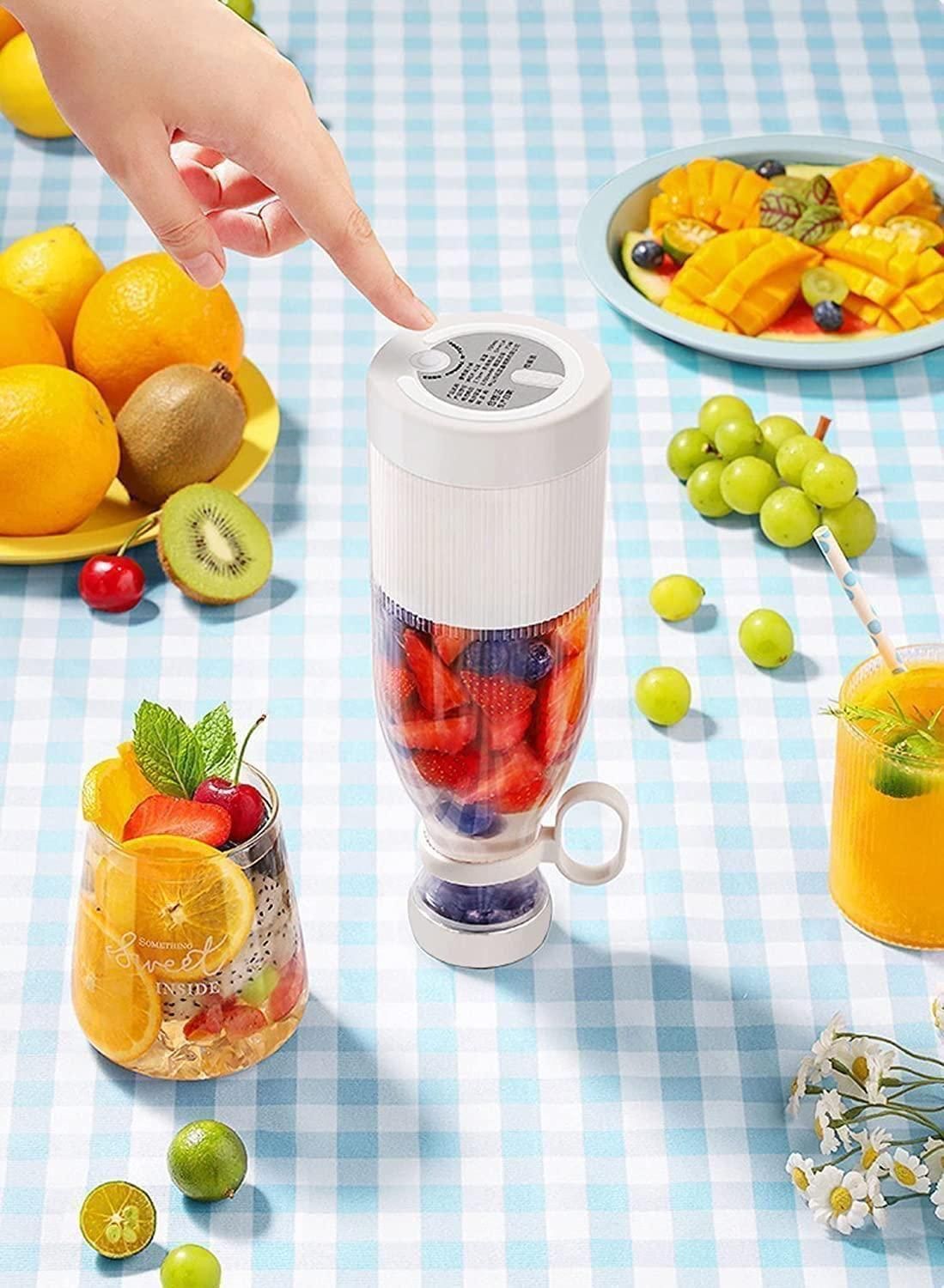 Small blender with fruits and a smoothie on a checkered tablecloth